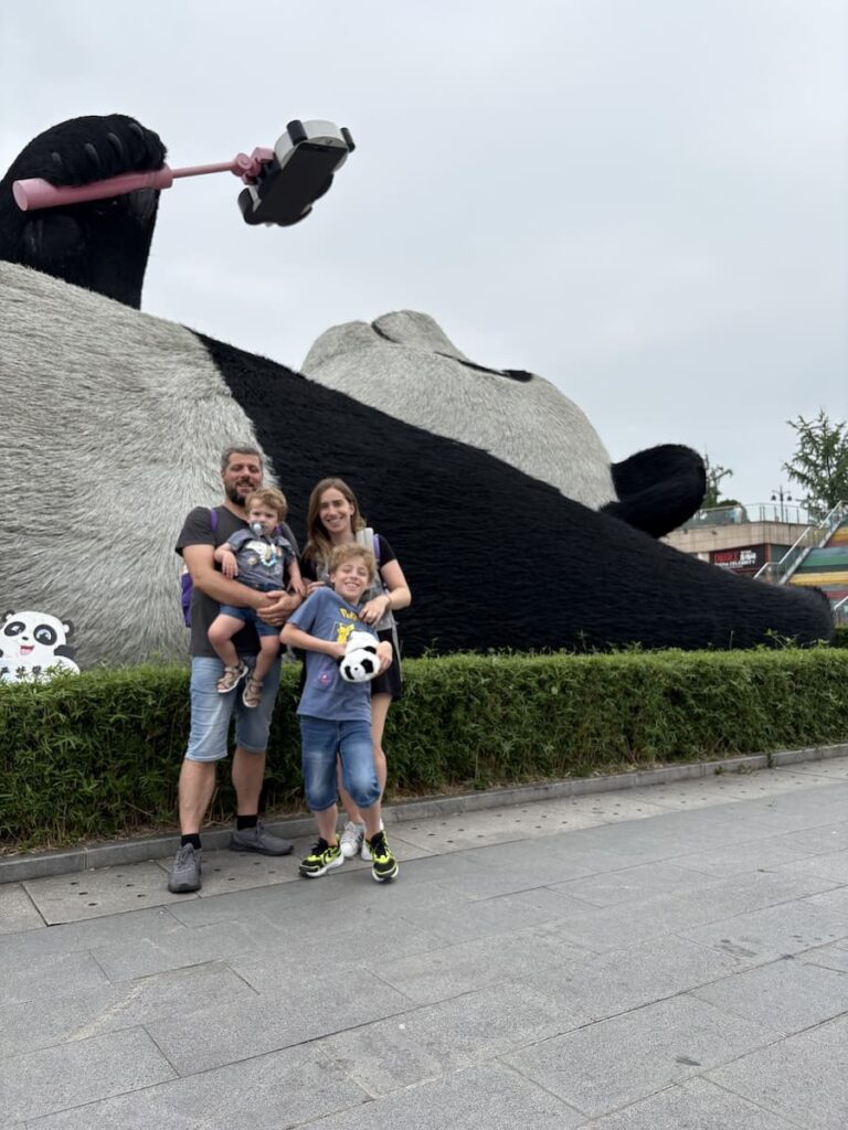 famiglia davanti a statua panda